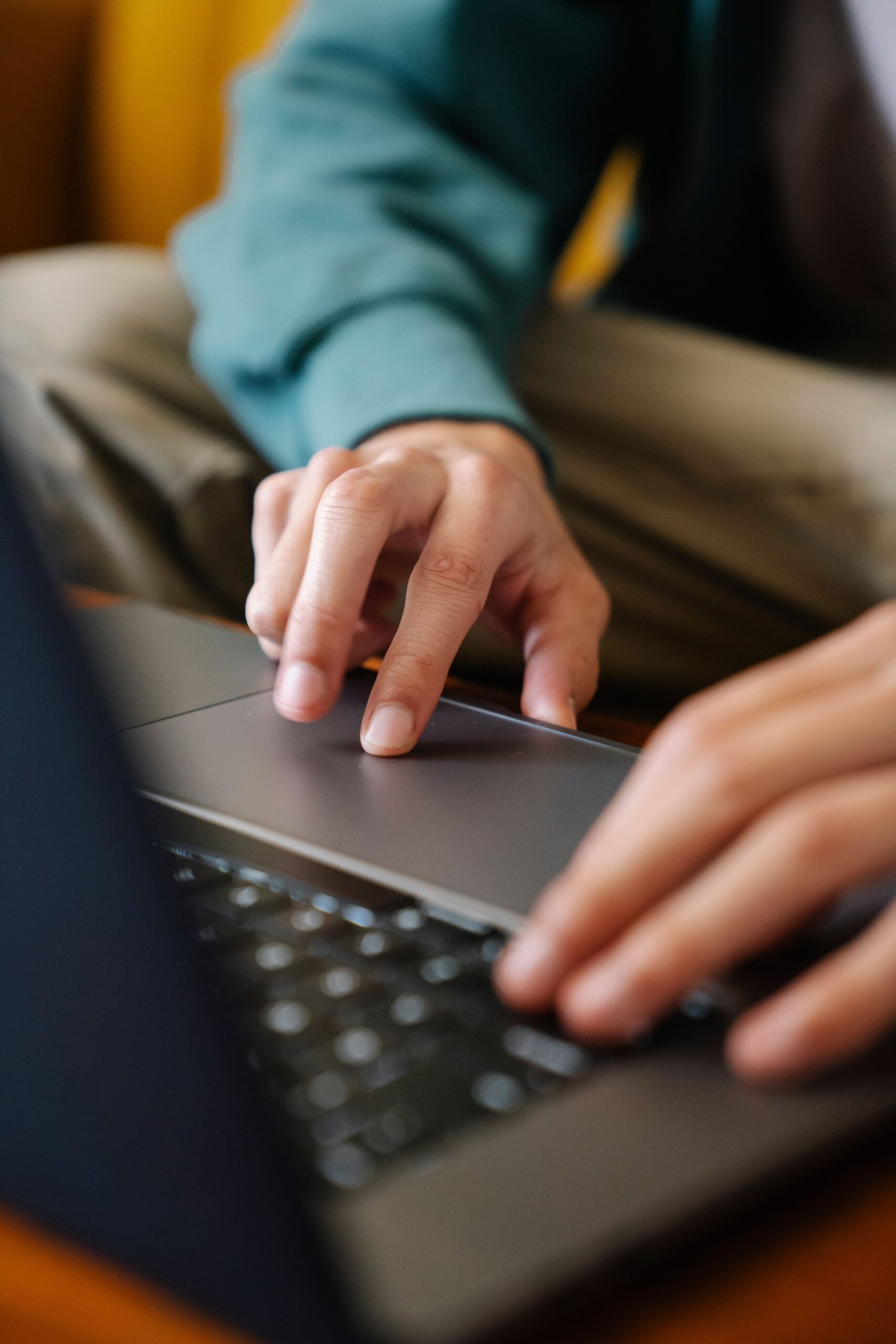 Hands in focus while typing on a laptop, showcasing technology and work indoors.